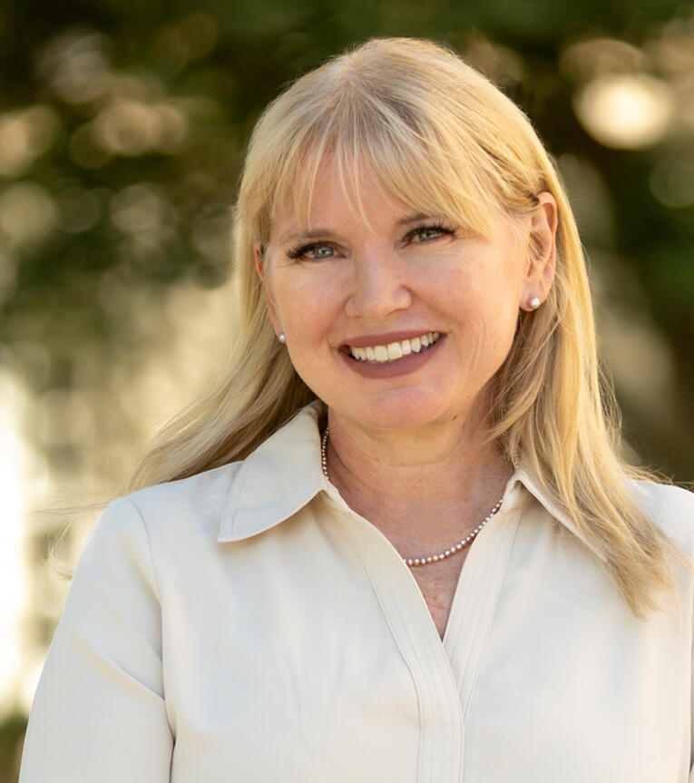 headshot of Lori with blonde hair and cream-colored shirt